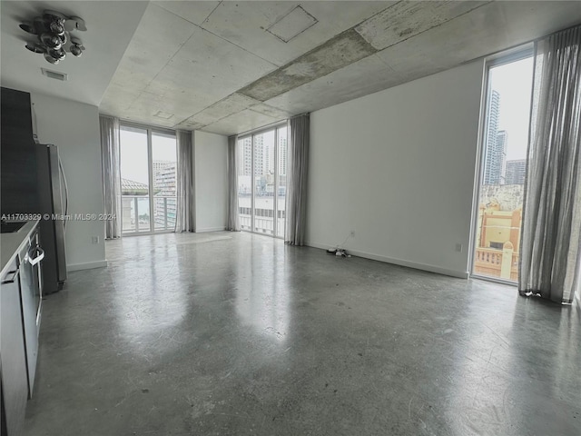 unfurnished room with ceiling fan and concrete flooring