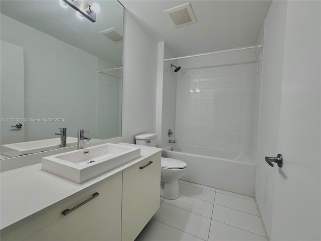 full bathroom featuring tiled shower / bath, tile patterned flooring, vanity, and toilet