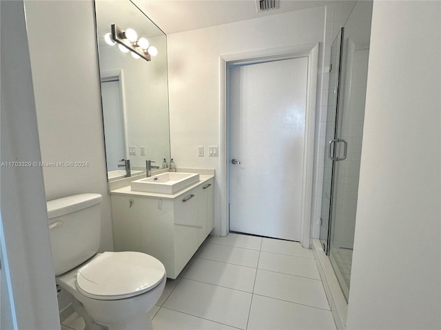 bathroom featuring tile patterned floors, vanity, toilet, and an enclosed shower