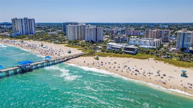 drone / aerial view featuring a beach view and a water view