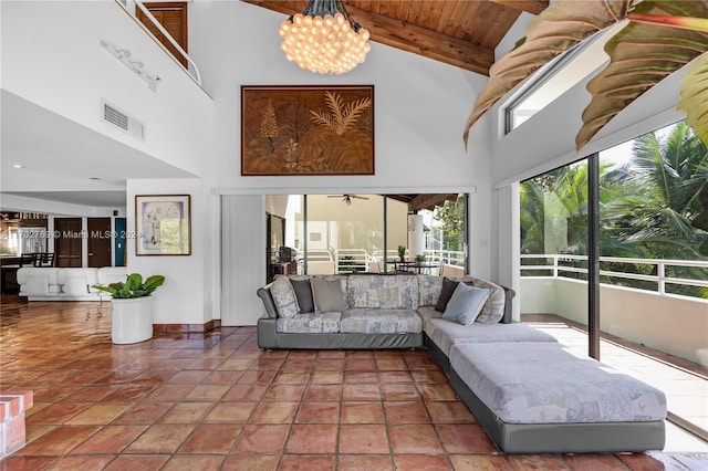 tiled living room featuring a chandelier, beam ceiling, high vaulted ceiling, and wood ceiling