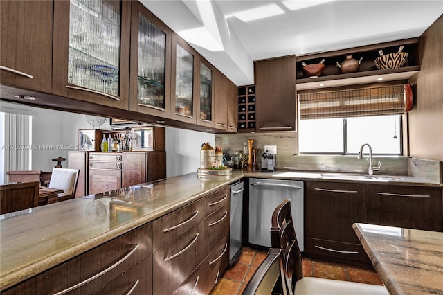 kitchen with dishwasher, sink, tasteful backsplash, light stone counters, and dark brown cabinetry