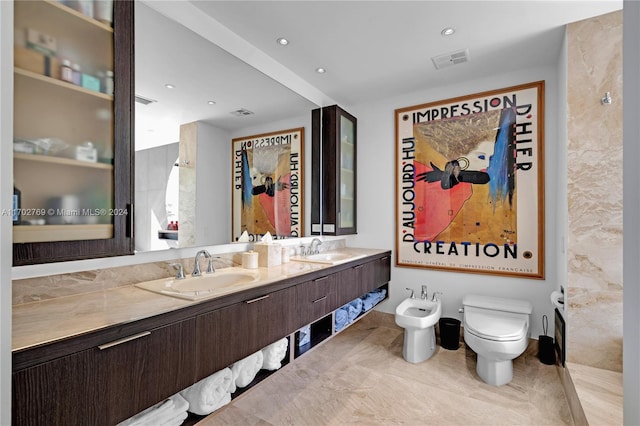 bathroom with vanity, toilet, and a bidet