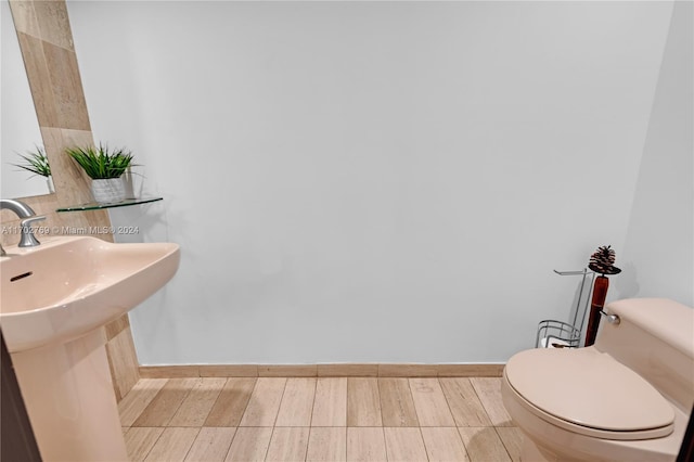 bathroom featuring hardwood / wood-style flooring, toilet, and sink