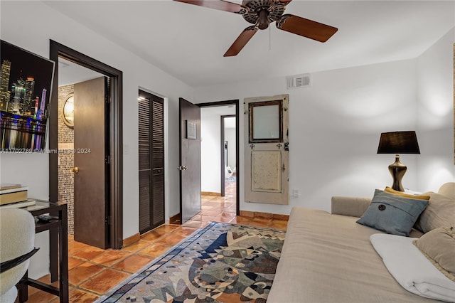 bedroom with ceiling fan, light tile patterned floors, and a closet