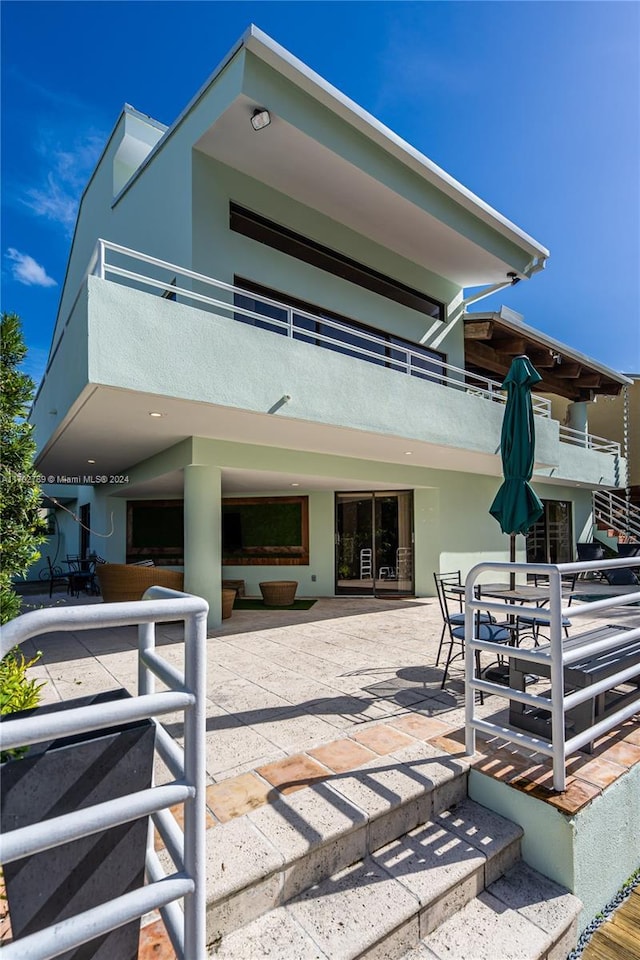 back of property with a patio area and a balcony