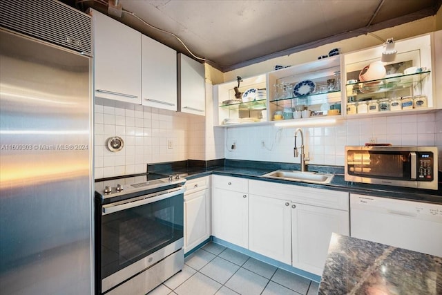 kitchen with tasteful backsplash, stainless steel appliances, sink, light tile patterned floors, and white cabinets