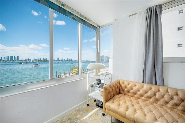 sunroom / solarium featuring a water view and a healthy amount of sunlight