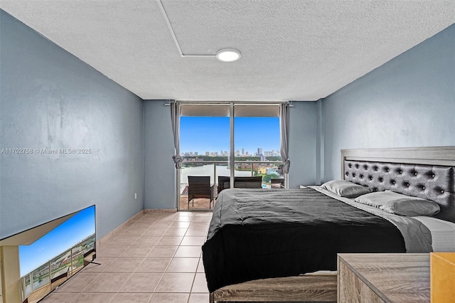 tiled bedroom featuring access to outside and a textured ceiling