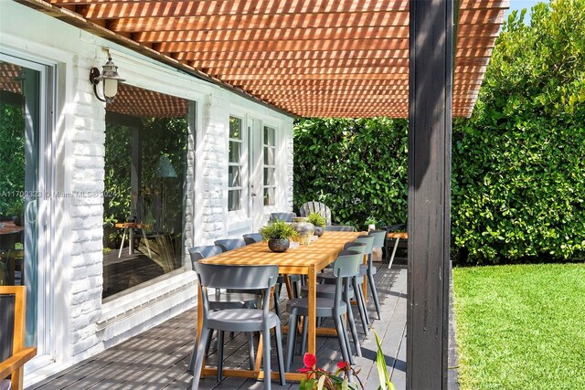 wooden terrace featuring outdoor dining space and a pergola