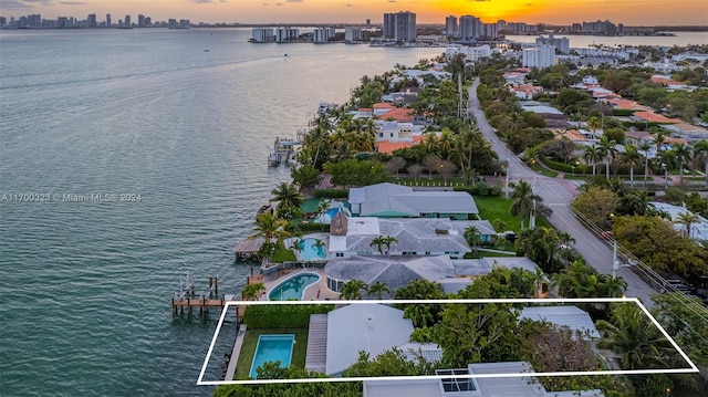 aerial view at dusk with a water view and a city view