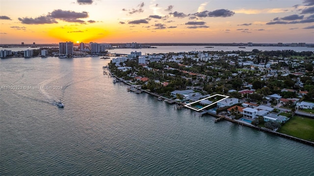 aerial view at dusk with a water view and a city view