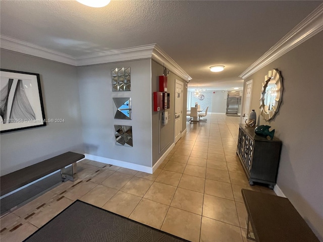 hallway featuring a textured ceiling, crown molding, and light tile patterned flooring