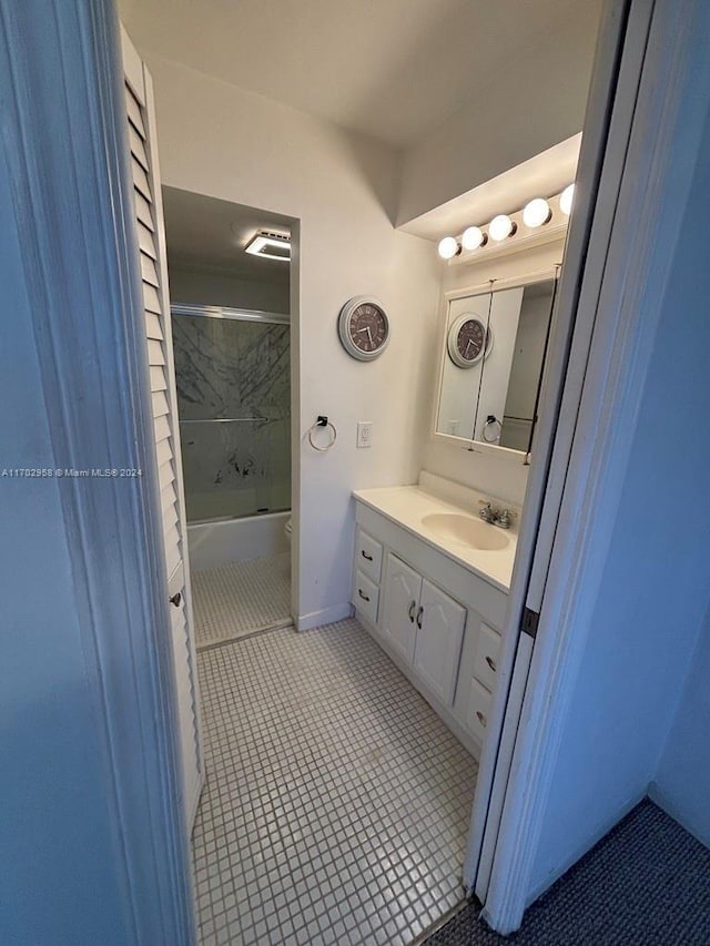 full bathroom with tile patterned flooring, vanity, bath / shower combo with glass door, and toilet