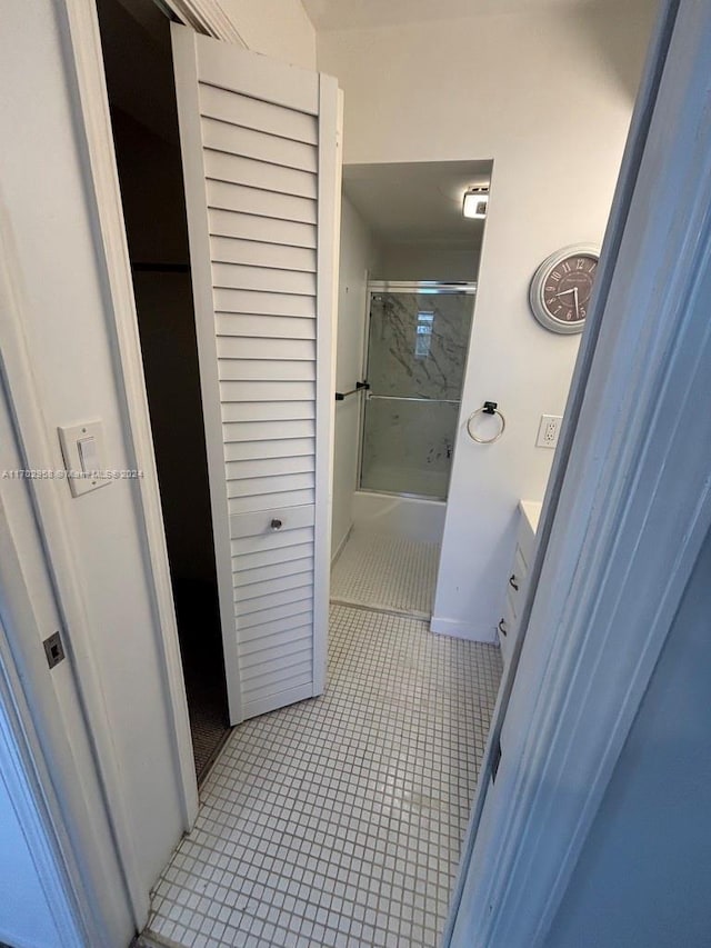 bathroom with combined bath / shower with glass door, vanity, and tile patterned flooring