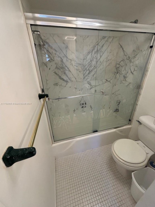 bathroom with tile patterned flooring, toilet, and enclosed tub / shower combo