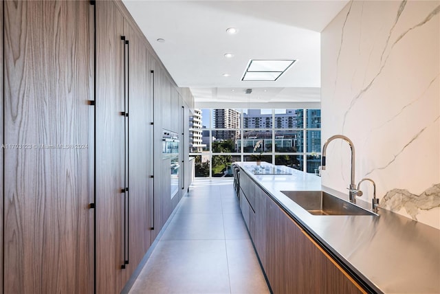 kitchen featuring expansive windows, sink, and oven