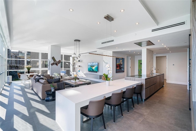 kitchen featuring a large island with sink, decorative light fixtures, and a breakfast bar area