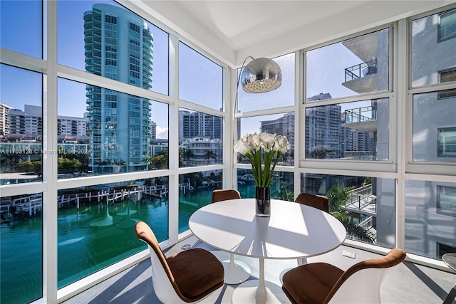 sunroom featuring a water view