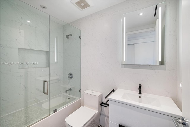 full bathroom with vanity, toilet, shower / bath combination with glass door, and tile walls