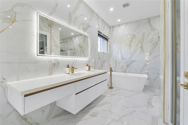 bathroom featuring a tub to relax in, vanity, and tile walls