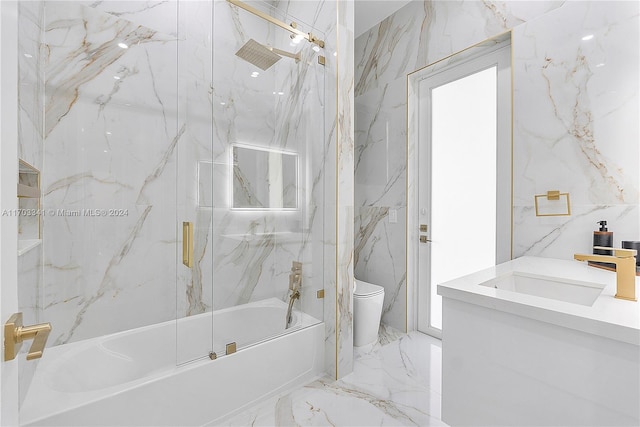 full bathroom featuring vanity, bath / shower combo with glass door, and toilet