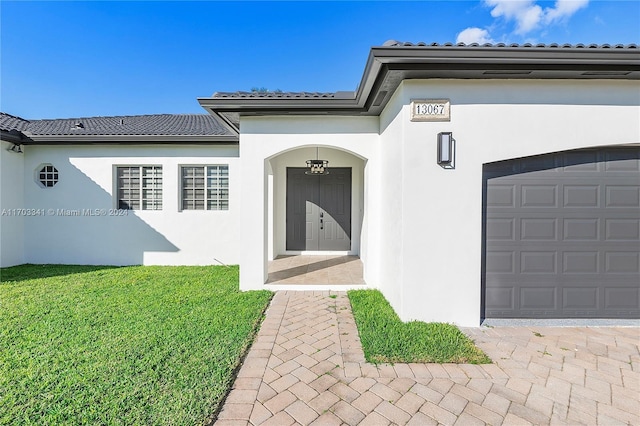 doorway to property featuring a yard and a garage