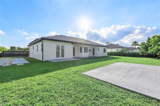 rear view of property with a lawn, french doors, and a patio