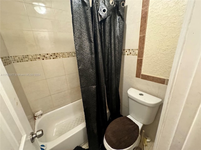 bathroom featuring shower / tub combo with curtain, tile walls, and toilet