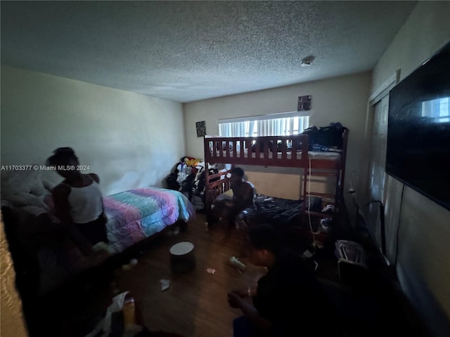 bedroom with a textured ceiling and hardwood / wood-style flooring