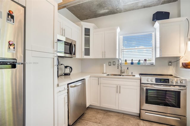 kitchen featuring white cabinetry, sink, light tile patterned flooring, and stainless steel appliances