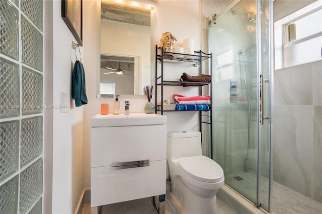 bathroom with vanity, ceiling fan, toilet, and a shower with shower door