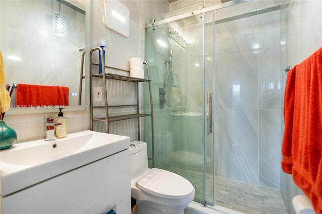 bathroom with vanity, toilet, and a shower with shower door