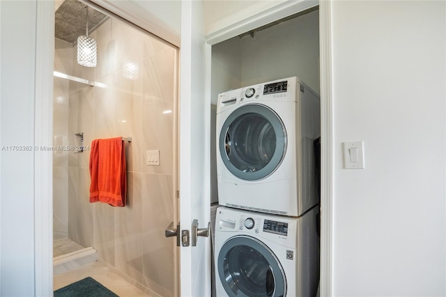 laundry room with tile patterned flooring and stacked washer / drying machine