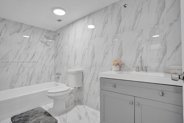 full bathroom featuring tiled shower / bath, vanity, toilet, and tile walls