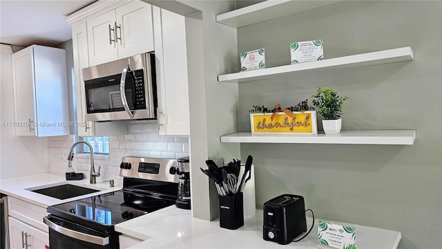 kitchen featuring white cabinets, backsplash, sink, and stainless steel appliances