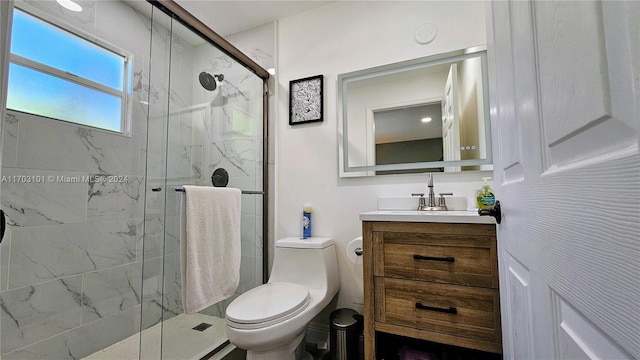 bathroom with vanity, toilet, and a shower with door