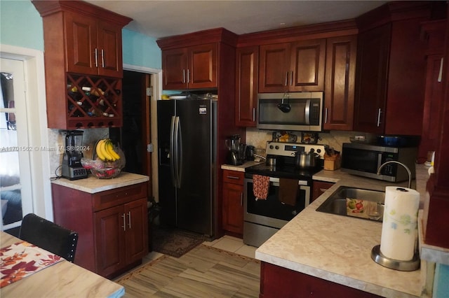 kitchen featuring backsplash, sink, and appliances with stainless steel finishes