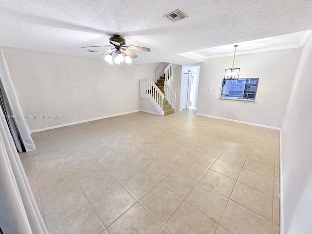 unfurnished living room with a textured ceiling, light tile patterned floors, ceiling fan with notable chandelier, and ornamental molding