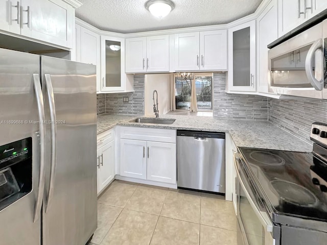 kitchen featuring white cabinets, light tile patterned floors, sink, and appliances with stainless steel finishes