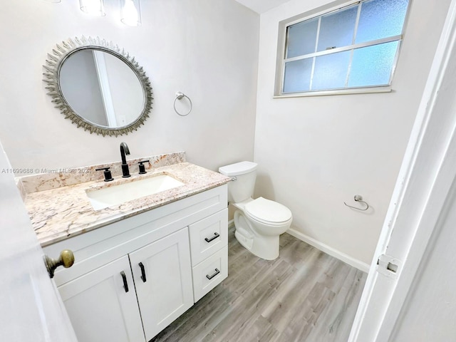 bathroom with toilet, vanity, and hardwood / wood-style flooring