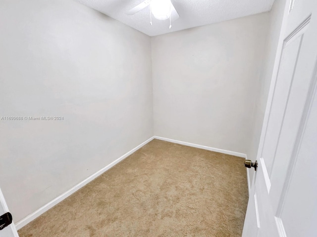 unfurnished room featuring a textured ceiling, ceiling fan, and light carpet