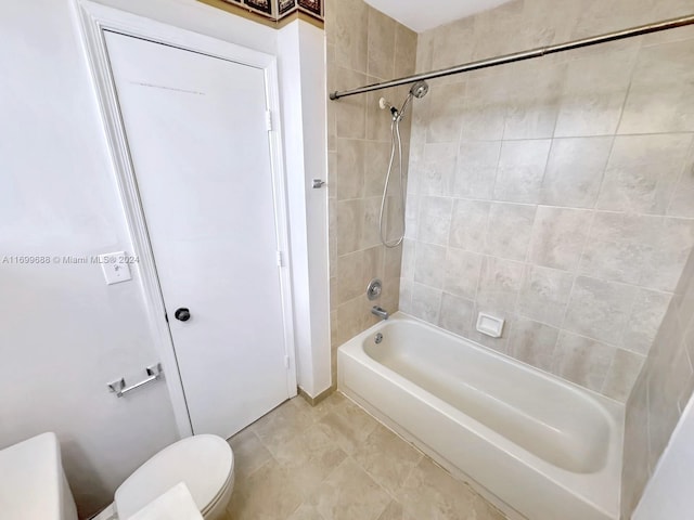 bathroom with toilet and tiled shower / bath