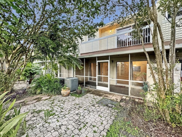 back of property with a patio area, a sunroom, a balcony, and central AC unit