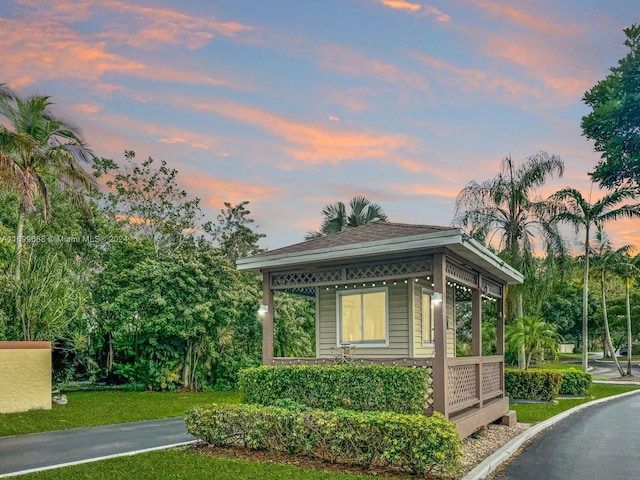 property exterior at dusk featuring a yard