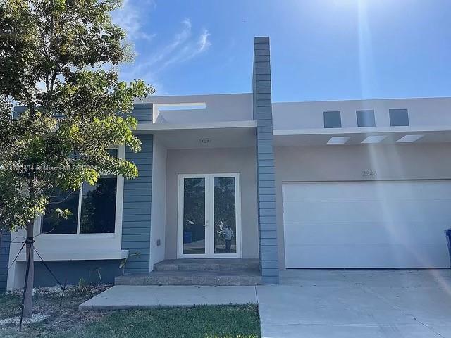 back of property with french doors and a garage