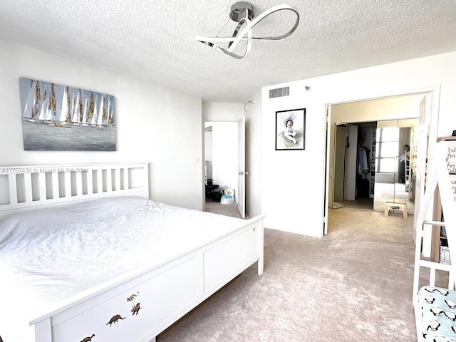 carpeted bedroom featuring a textured ceiling