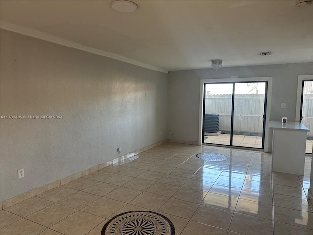 spare room featuring crown molding and light tile patterned floors