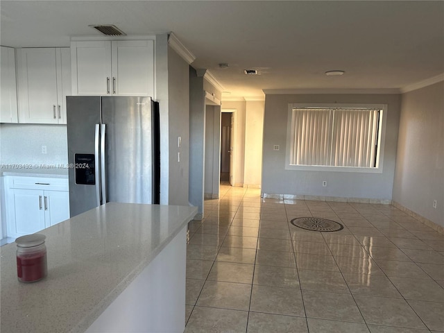 kitchen featuring white cabinetry, crown molding, light stone counters, and stainless steel refrigerator with ice dispenser