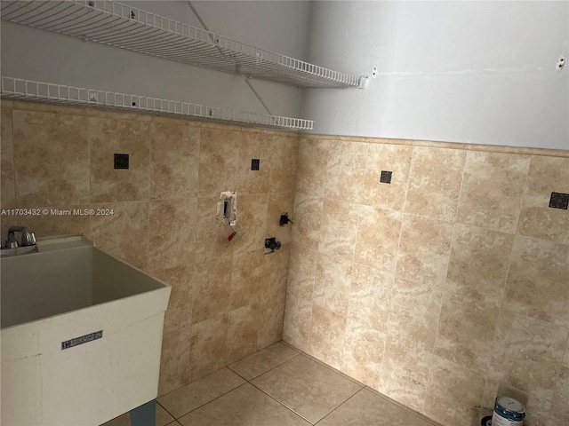 laundry area featuring tile patterned floors, tile walls, and sink